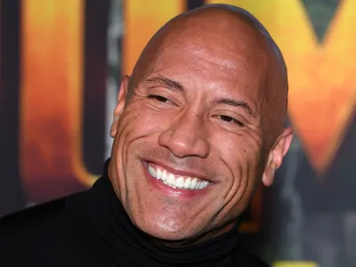 Which professional sport did The Rock play briefly before pursuing a wrestling career?