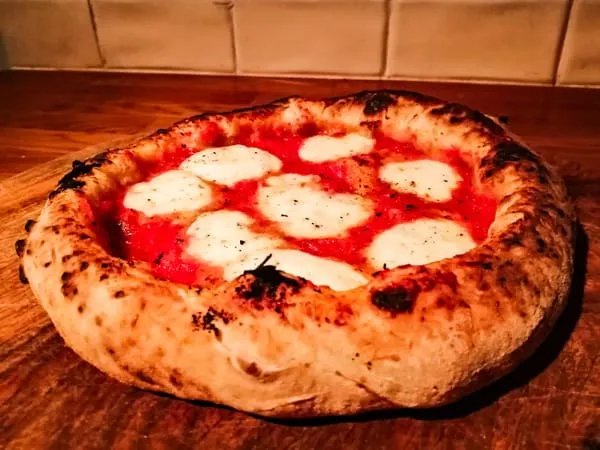What is the traditional crust style of a Neapolitan pizza?