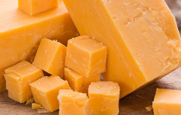 Which cheese is known for its crumbly texture and tangy flavor?