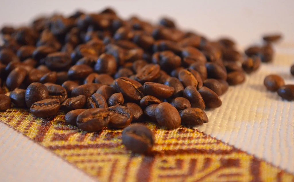 Which term refers to the process of removing the outer layers of the coffee cherry to extract the beans?
