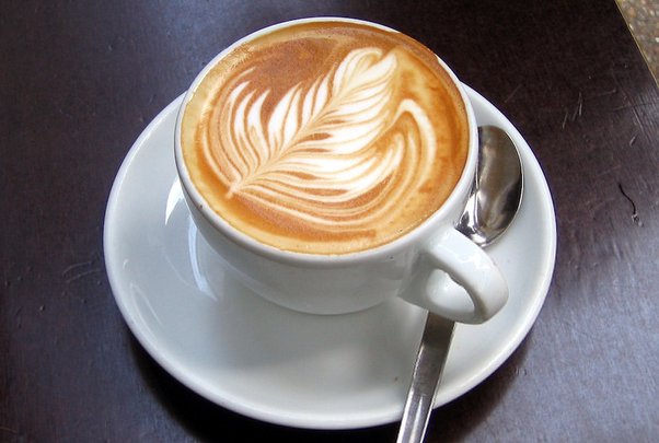 Which type of coffee is made by combining equal parts espresso and hot water, and topping it with a layer of foam?