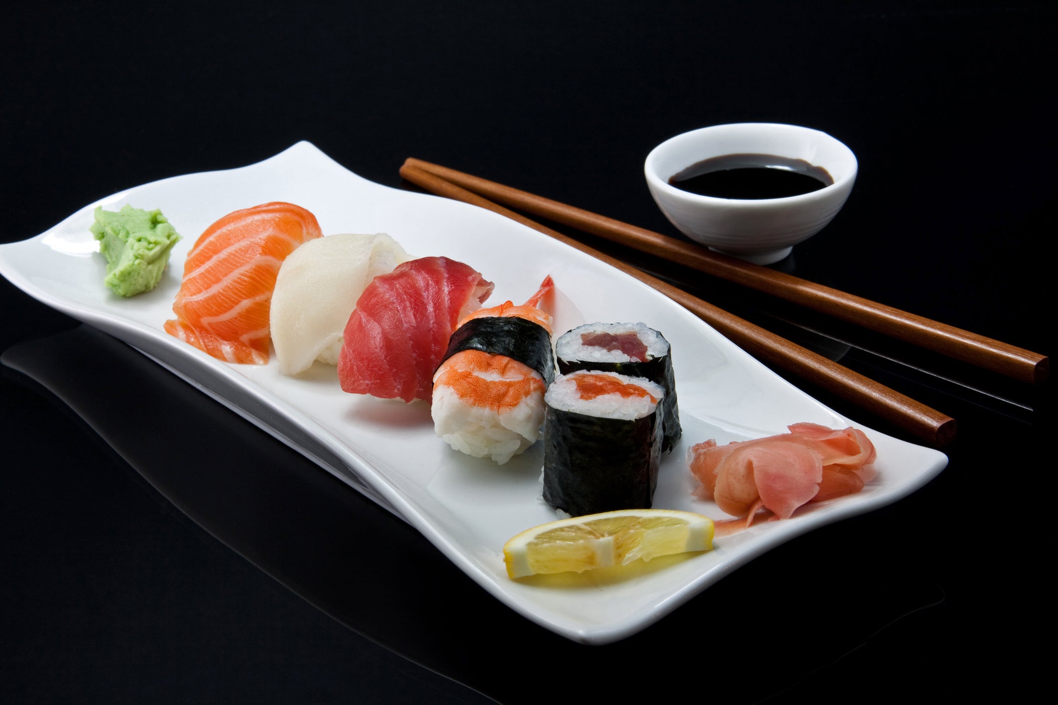 What is the name of the thin slice of raw fish or seafood served over a small mound of rice?