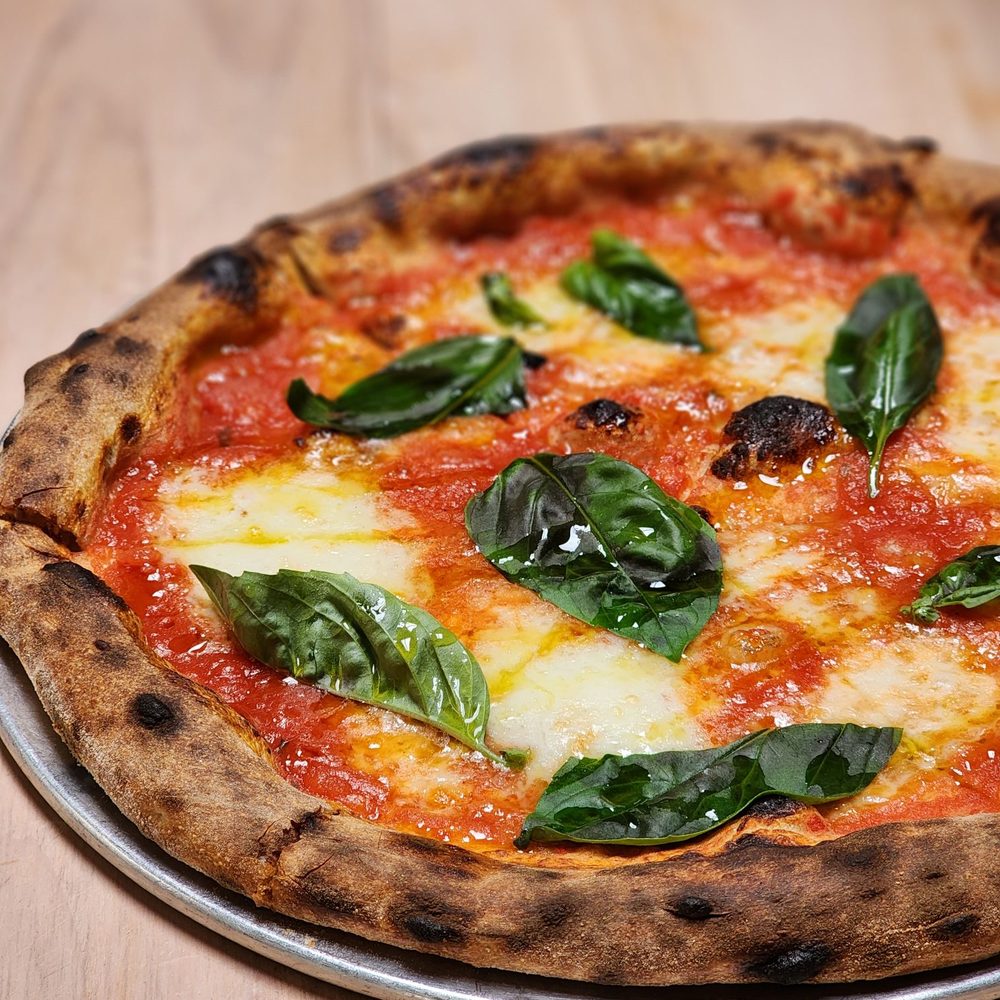 Which country is known for its 'tarte flambée' pizza?